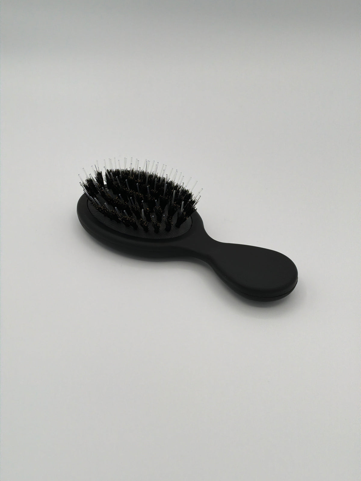 Mini matte black hair extension brush with personalized gold logo