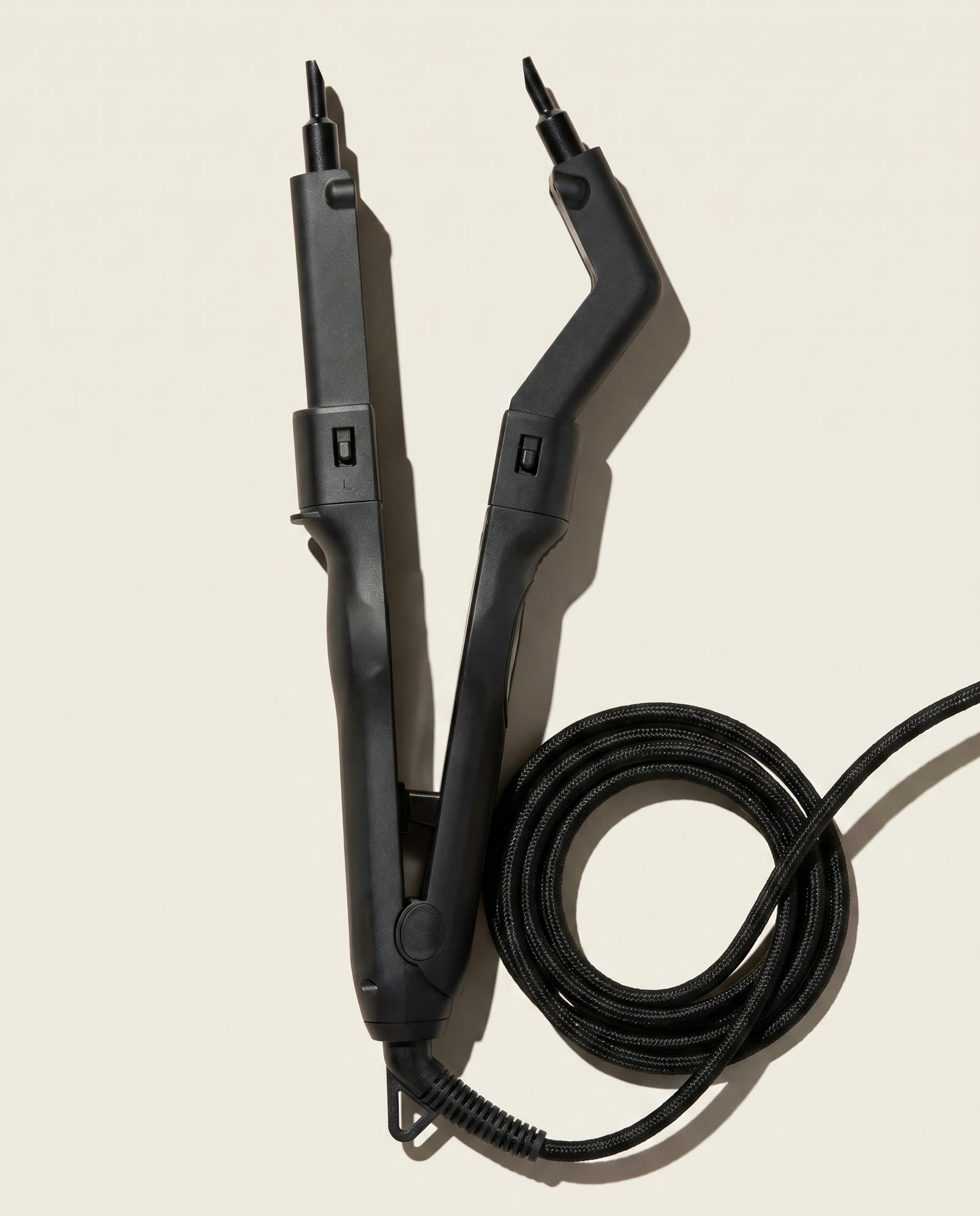 Omni-Fusion tool with its coiled braided cord on a cream backdrop